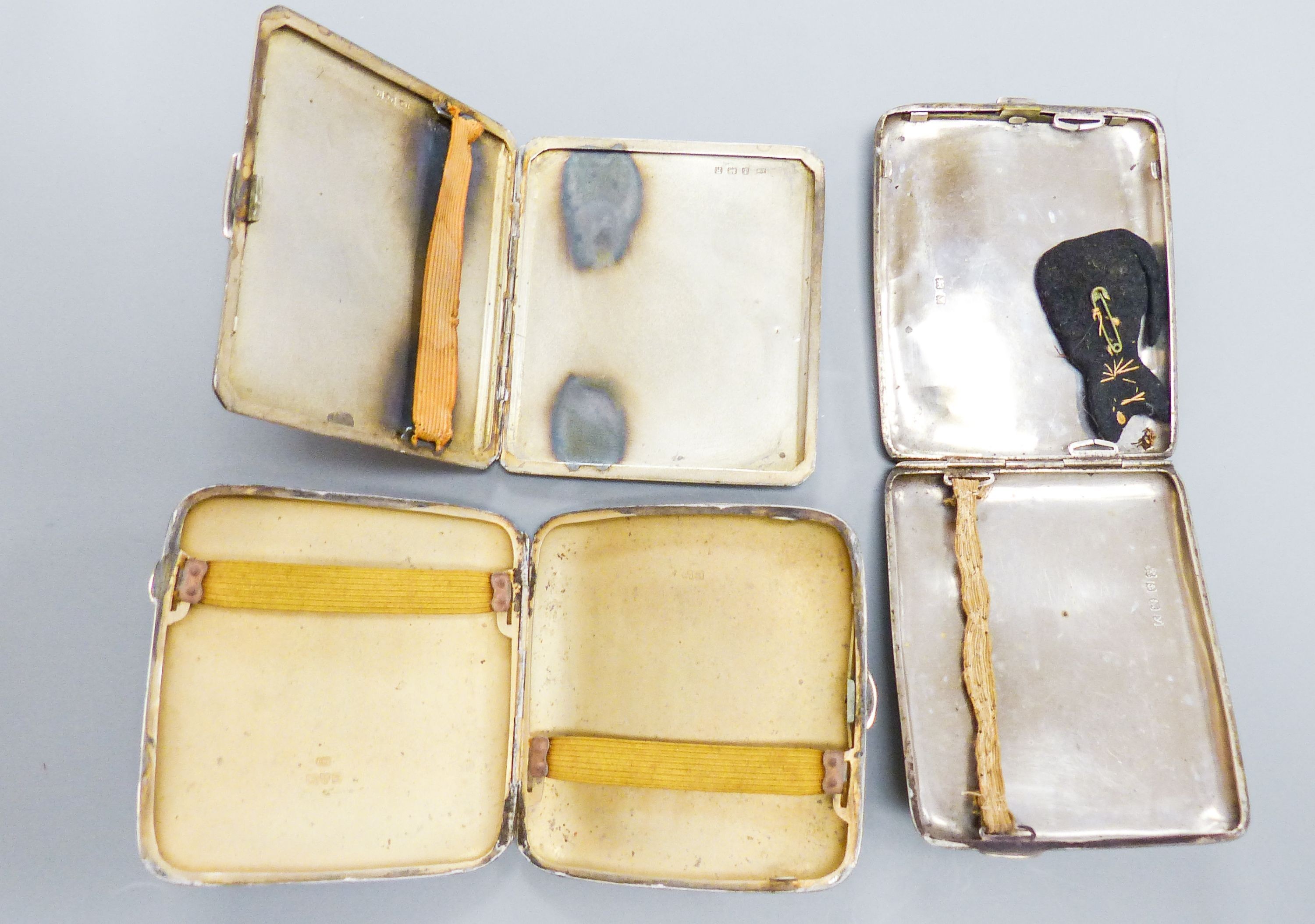 Three assorted George V silver cigarette cases, largest 9.8cm, gross weight 11.5oz.